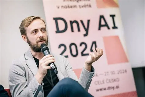 A speaker holding a microphone in front of AI Days 2024 signage