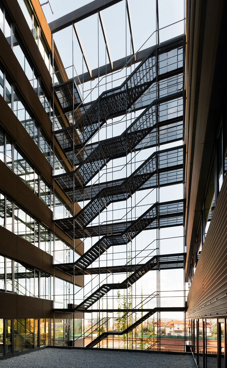 Tall glass atrium crossed by exposed metal staircases